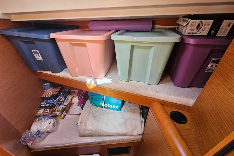 Urkab Yacht Photos Pics Storage area in a 2018 Jeanneau Sun Odyssey 449 with colorful bins and supplies.