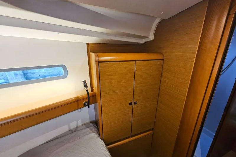 Urkab Yacht Photos Pics Interior cabin of 2018 Jeanneau Sun Odyssey 449 with wooden cabinetry and window.