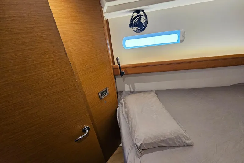 Urkab Yacht Photos Pics Cozy cabin interior of 2018 Jeanneau Sun Odyssey 449 sailboat with wooden door and bed.