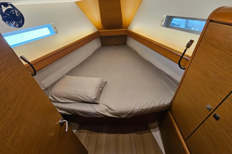Urkab Yacht Photos Pics Cozy cabin interior of 2018 Jeanneau Sun Odyssey 449 sailboat with bed and wooden finish.