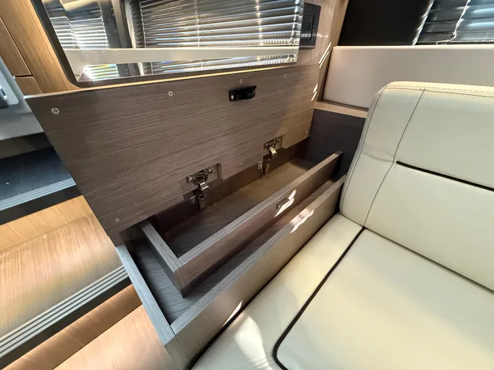  Yacht Photos Pics 2023 Wellcraft 38 Explorer interior with open wooden storage drawers and beige seating.
