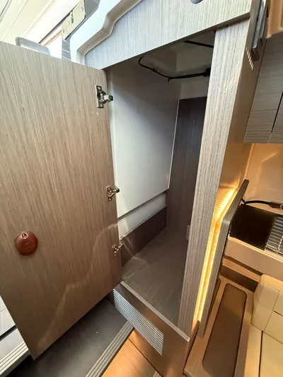  Yacht Photos Pics 2023 Wellcraft 38 Explorer interior storage cabinet with open door, showcasing modern design.