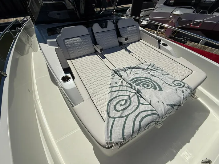  Yacht Photos Pics 2023 Wellcraft 38 Explorer boat with cushioned sunbathing area and patterned towel.