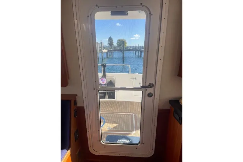  Yacht Photos Pics Interior view through door of 2006 Nordic Tug 42, overlooking water and dock.