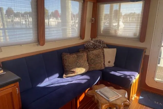  Yacht Photos Pics Cozy interior of 2006 Nordic Tug 42 with blue seating and decorative pillows.