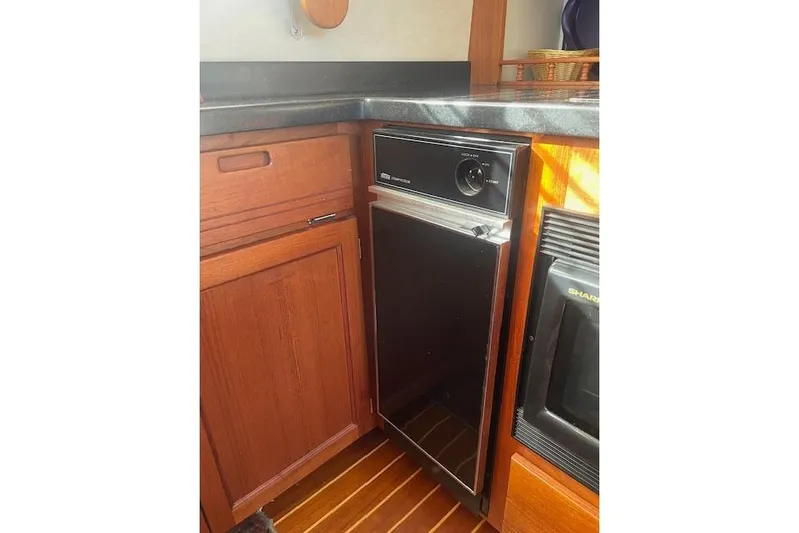  Yacht Photos Pics 2006 Nordic Tug 42 interior kitchen with wooden cabinetry and compact appliances.