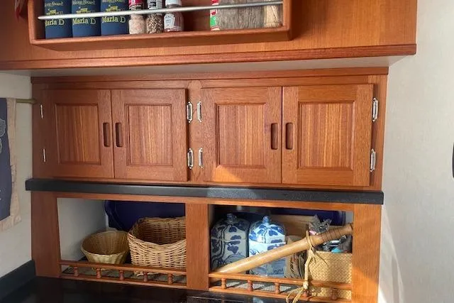  Yacht Photos Pics Wooden cabinetry in a 2006 Nordic Tug 42, featuring storage baskets and pantry items.