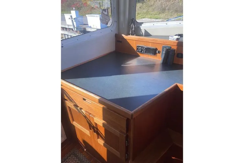  Yacht Photos Pics 2006 Nordic Tug 42 interior with wooden cabinetry and navigation equipment.