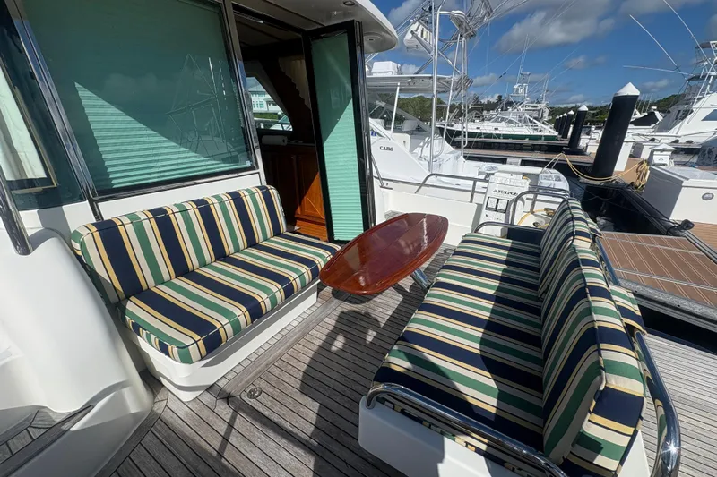  Yacht Photos Pics 2016 Sabre 38 Salon Express yacht with striped seating and wooden table on deck.