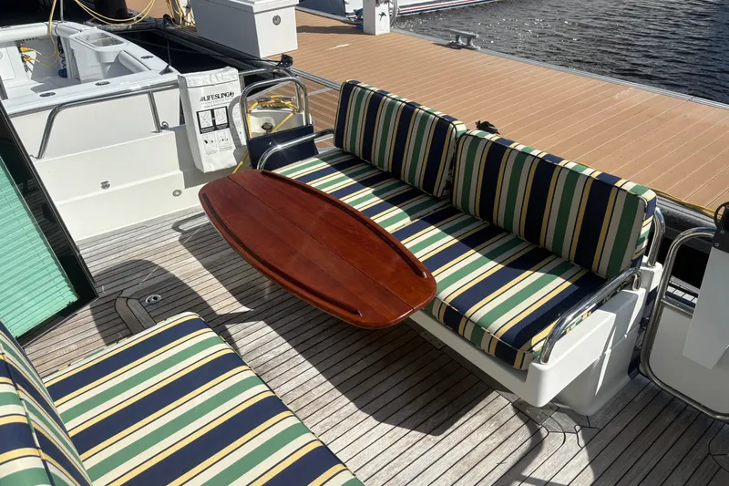 Yacht Photos Pics 2016 Sabre 38 Salon Express yacht deck with striped seating and wooden table.
