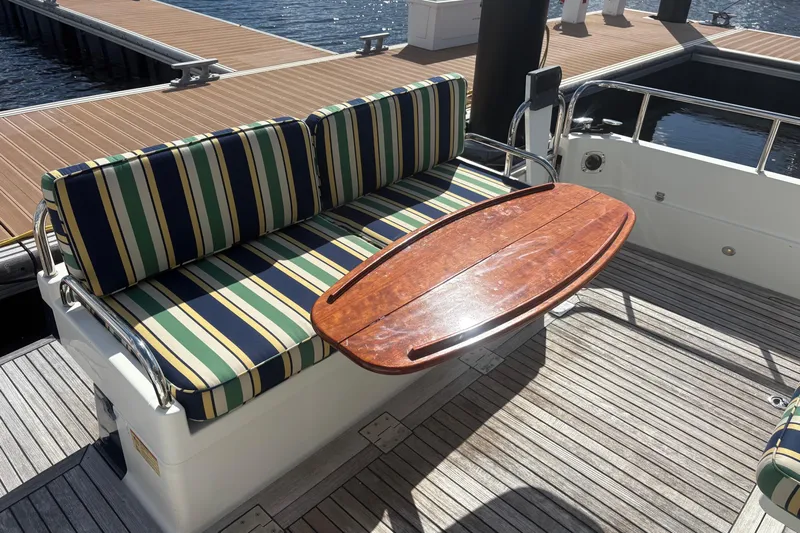  Yacht Photos Pics Striped seating and wooden table on 2016 Sabre 38 Salon Express yacht deck.