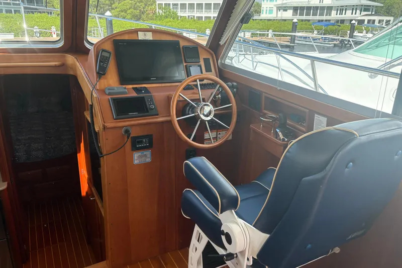  Yacht Photos Pics 2016 Sabre 38 Salon Express helm with wooden dashboard and blue captain's chair.