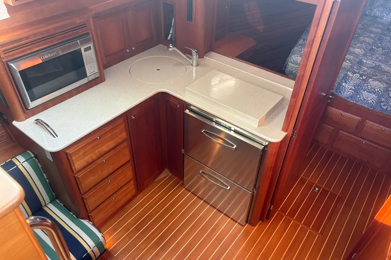  Yacht Photos Pics 2016 Sabre 38 Salon Express interior with kitchenette, featuring wood cabinetry and modern appliances.