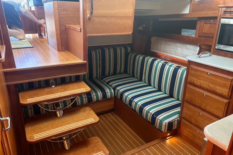  Yacht Photos Pics Interior of 2016 Sabre 38 Salon Express with striped seating and wooden cabinetry.