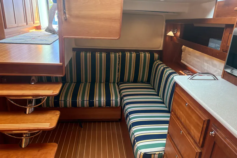  Yacht Photos Pics Interior of 2016 Sabre 38 Salon Express with striped seating and wooden cabinetry.