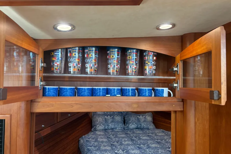  Yacht Photos Pics 2016 Sabre 38 Salon Express interior with wooden cabinets and nautical-themed glassware.