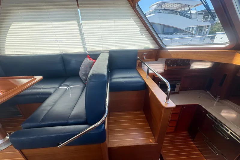  Yacht Photos Pics Interior of 2016 Sabre 38 Salon Express with blue seating and wooden finishes.
