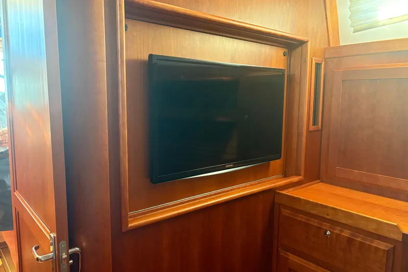  Yacht Photos Pics Interior of 2016 Sabre 38 Salon Express with built-in TV and wooden cabinetry.