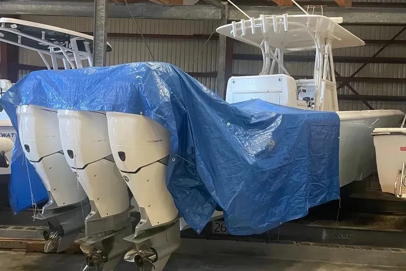  Yacht Photos Pics 2018 SeaVee 340Z boat with triple outboard engines, partially covered by a blue tarp.
