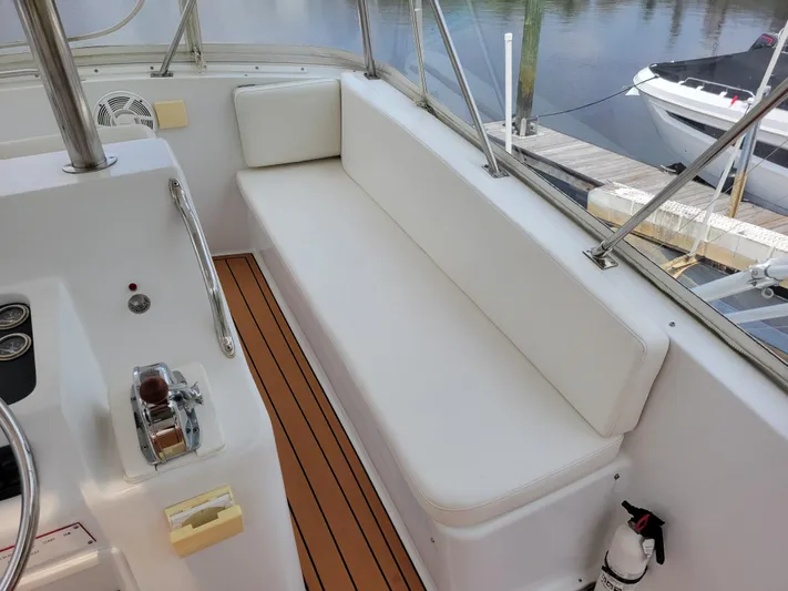 The Dog Patch Yacht Photos Pics 1990 Ocean Yachts 48 Super Sport interior with white seating and wooden flooring.