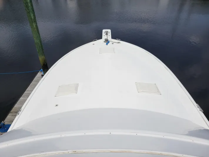 The Dog Patch Yacht Photos Pics Bow view of 1990 Ocean Yachts 48 Super Sport docked on calm water.