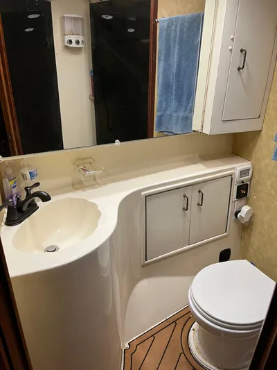 The Dog Patch Yacht Photos Pics Bathroom interior of 1990 Ocean Yachts 48 Super Sport with sink, toilet, and storage cabinets.