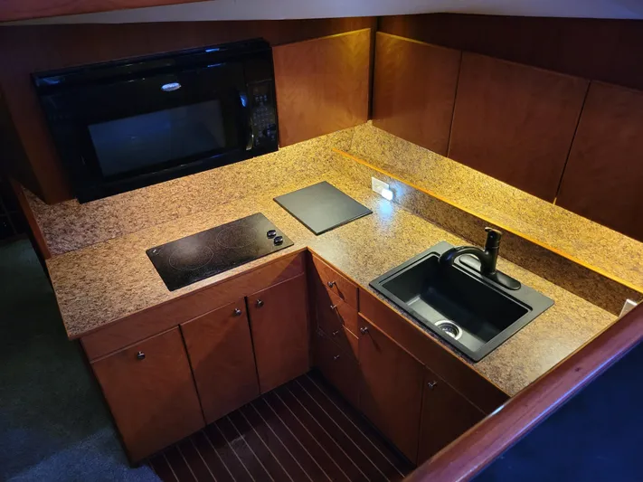 The Dog Patch Yacht Photos Pics Luxurious kitchen in 1990 Ocean Yachts 48 Super Sport with modern appliances and wood cabinetry.