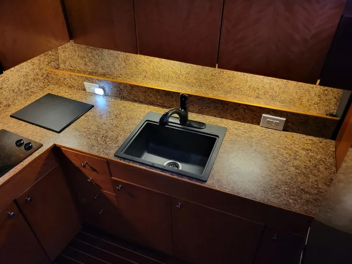 The Dog Patch Yacht Photos Pics Kitchen area of 1990 Ocean Yachts 48 Super Sport with sink and stovetop.