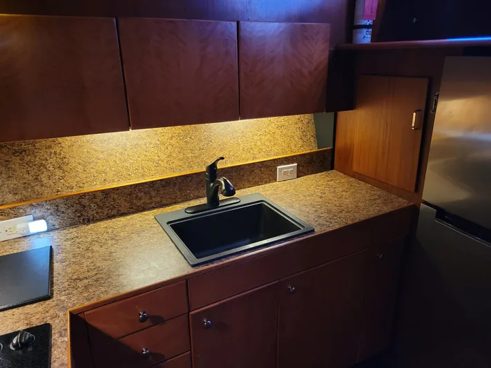 The Dog Patch Yacht Photos Pics Kitchen area of 1990 Ocean Yachts 48 Super Sport with wood cabinets and granite countertop.