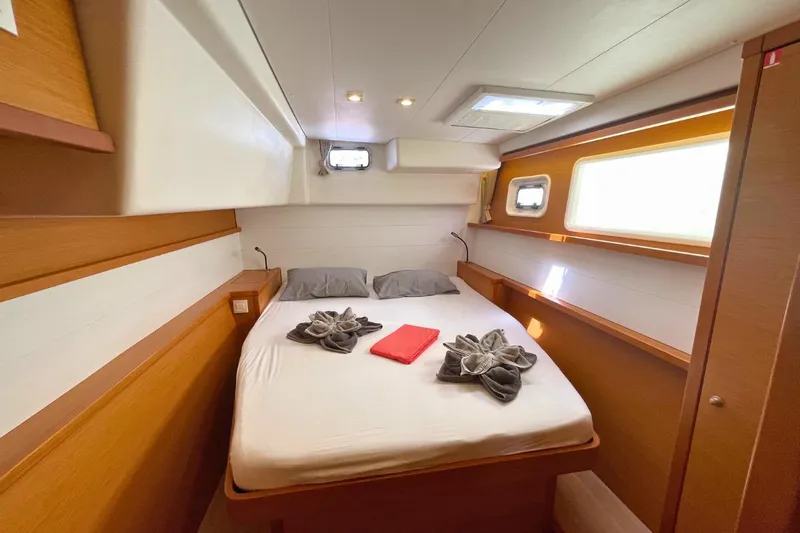 Take It Easy Yacht Photos Pics Luxurious cabin interior of 2018 Lagoon 450 F catamaran with cozy bed and elegant decor.