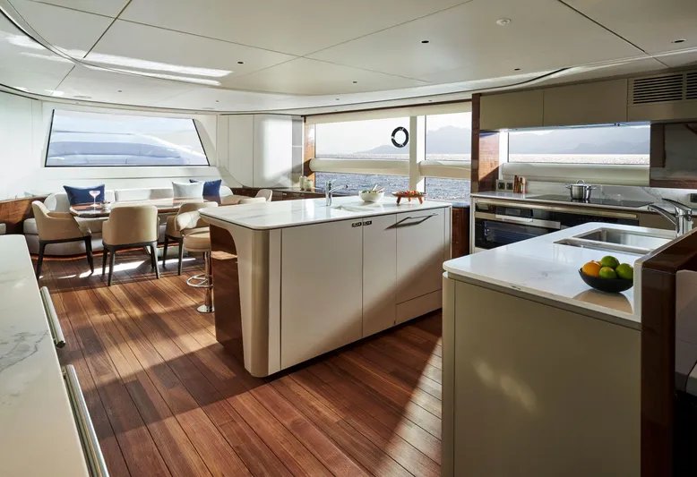  Yacht Photos Pics Luxurious interior of 2025 Princess X95 yacht with modern kitchen and dining area.