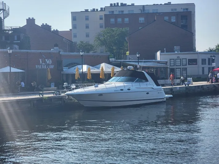  Yacht Photos Pics 2000 Cruisers 3870 Express yacht docked by waterfront buildings.