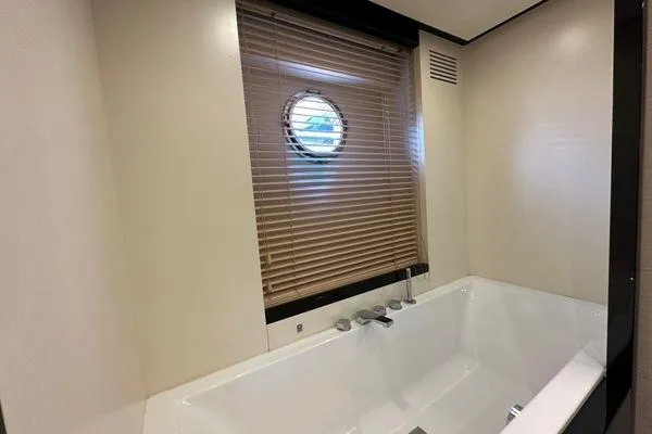  Yacht Photos Pics Luxurious bathroom with a bathtub and porthole window on a 2015 Azimut 80 yacht.