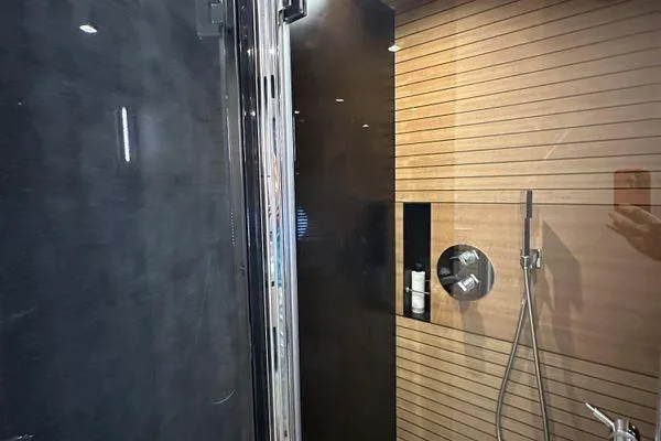  Yacht Photos Pics Luxurious shower area in 2015 Azimut 80 yacht with sleek black and wood paneling.