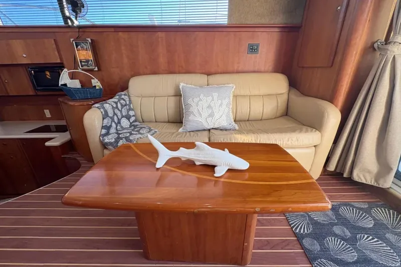  Yacht Photos Pics Interior of 2003 Silverton 42 Convertible yacht with beige sofa and wooden table.