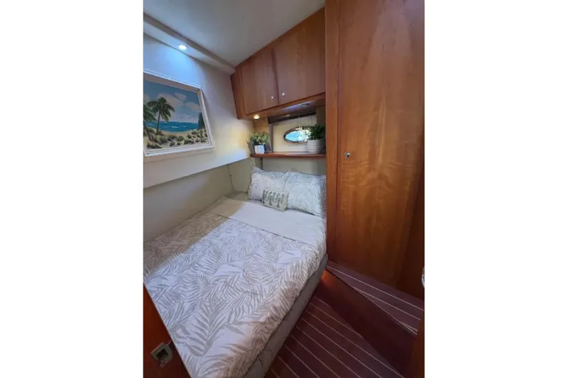  Yacht Photos Pics Cozy bedroom in 2003 Silverton 42 Convertible yacht with wood accents and tropical decor.