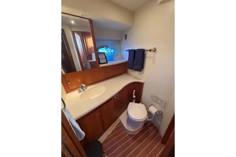  Yacht Photos Pics 2003 Silverton 42 Convertible yacht bathroom with modern fixtures and wooden cabinetry.