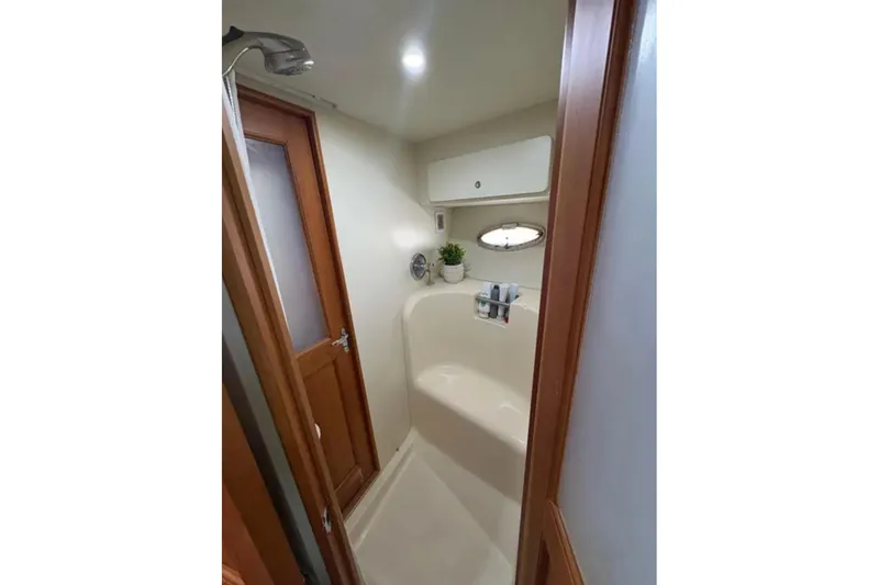  Yacht Photos Pics Bathroom interior of 2003 Silverton 42 Convertible yacht, featuring shower and wooden door.