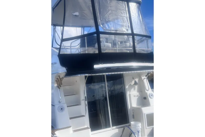  Yacht Photos Pics 2003 Silverton 42 Convertible yacht with enclosed flybridge and ladder, under a clear blue sky.