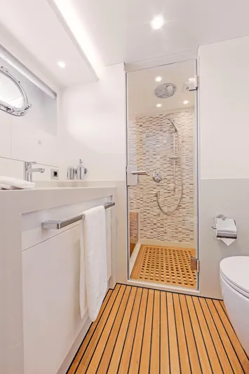  Yacht Photos Pics Modern yacht bathroom with wooden flooring, sleek fixtures, and a glass-enclosed shower. Van der Valk HELGA 2021.