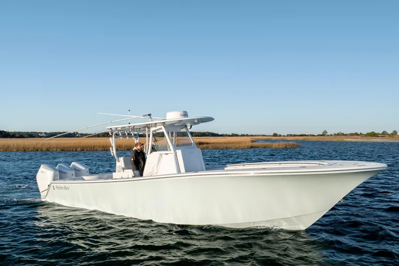  Yacht Photos Pics 2024 Onslow Bay 33 TE boat cruising on a calm waterway under clear blue skies.