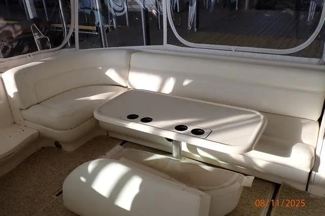  Yacht Photos Pics 2003 Sea Ray 460 Sundancer interior with white seating and table, featuring cup holders.
