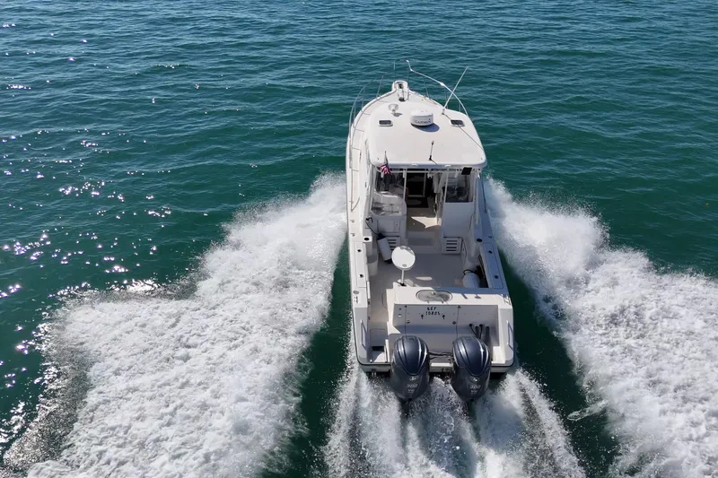  Yacht Photos Pics 2004 Pursuit 3370 Offshore boat cruising on open water, rear view.