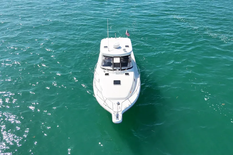  Yacht Photos Pics 2004 Pursuit 3370 Offshore boat on clear turquoise water, aerial view.