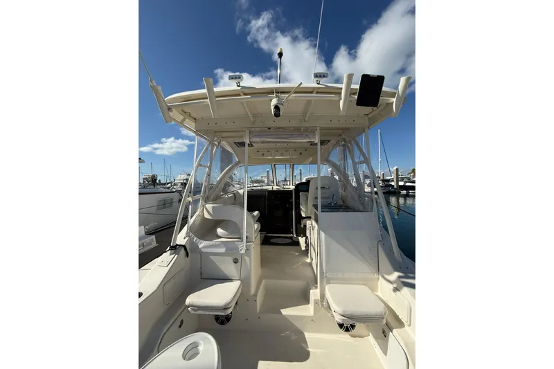  Yacht Photos Pics 2004 Pursuit 3370 Offshore boat interior with seating, docked at marina under blue sky.