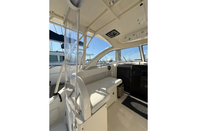  Yacht Photos Pics 2004 Pursuit 3370 Offshore boat interior with seating and clear enclosure.