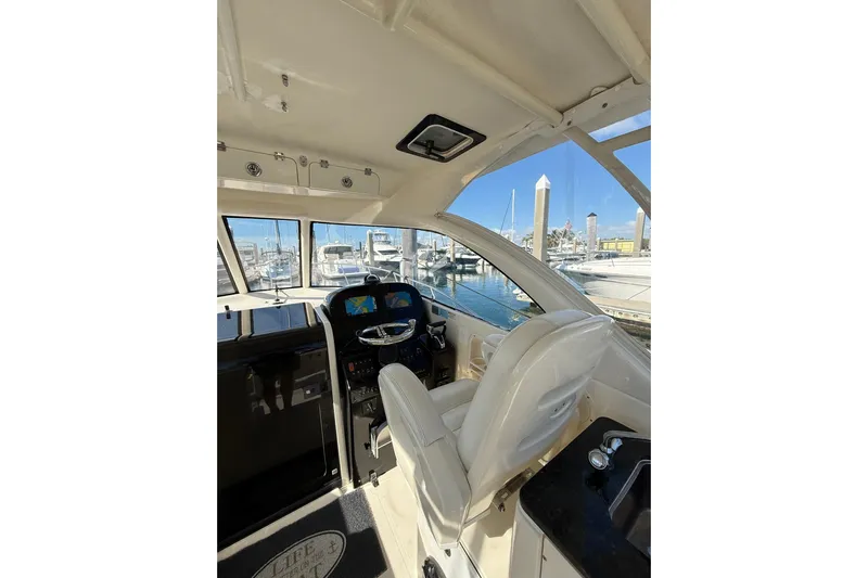  Yacht Photos Pics Interior view of 2004 Pursuit 3370 Offshore boat cockpit with marina background.