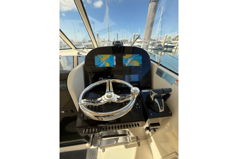  Yacht Photos Pics 2004 Pursuit 3370 Offshore helm with dual navigation screens and steering wheel.