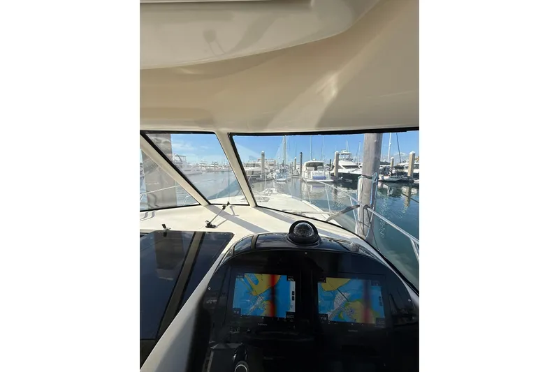  Yacht Photos Pics 2004 Pursuit 3370 Offshore boat cockpit view with navigation screens in a marina.