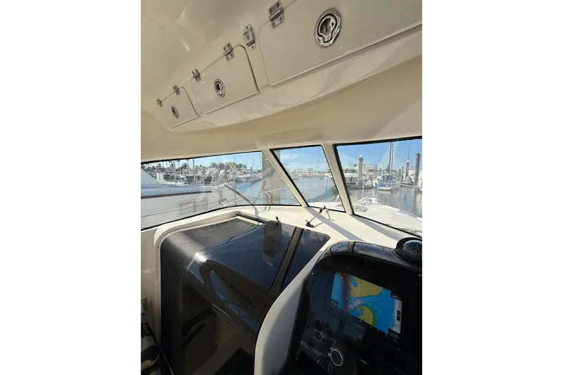  Yacht Photos Pics 2004 Pursuit 3370 Offshore boat interior with navigation system and marina view.